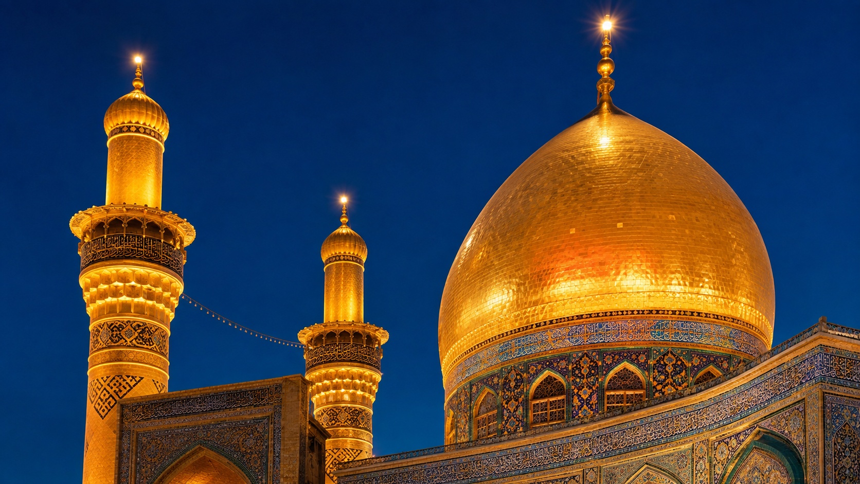 گنبد طلایی حرم حضرت عباس در گرگ‌ومیش با آسمان آبی تیره